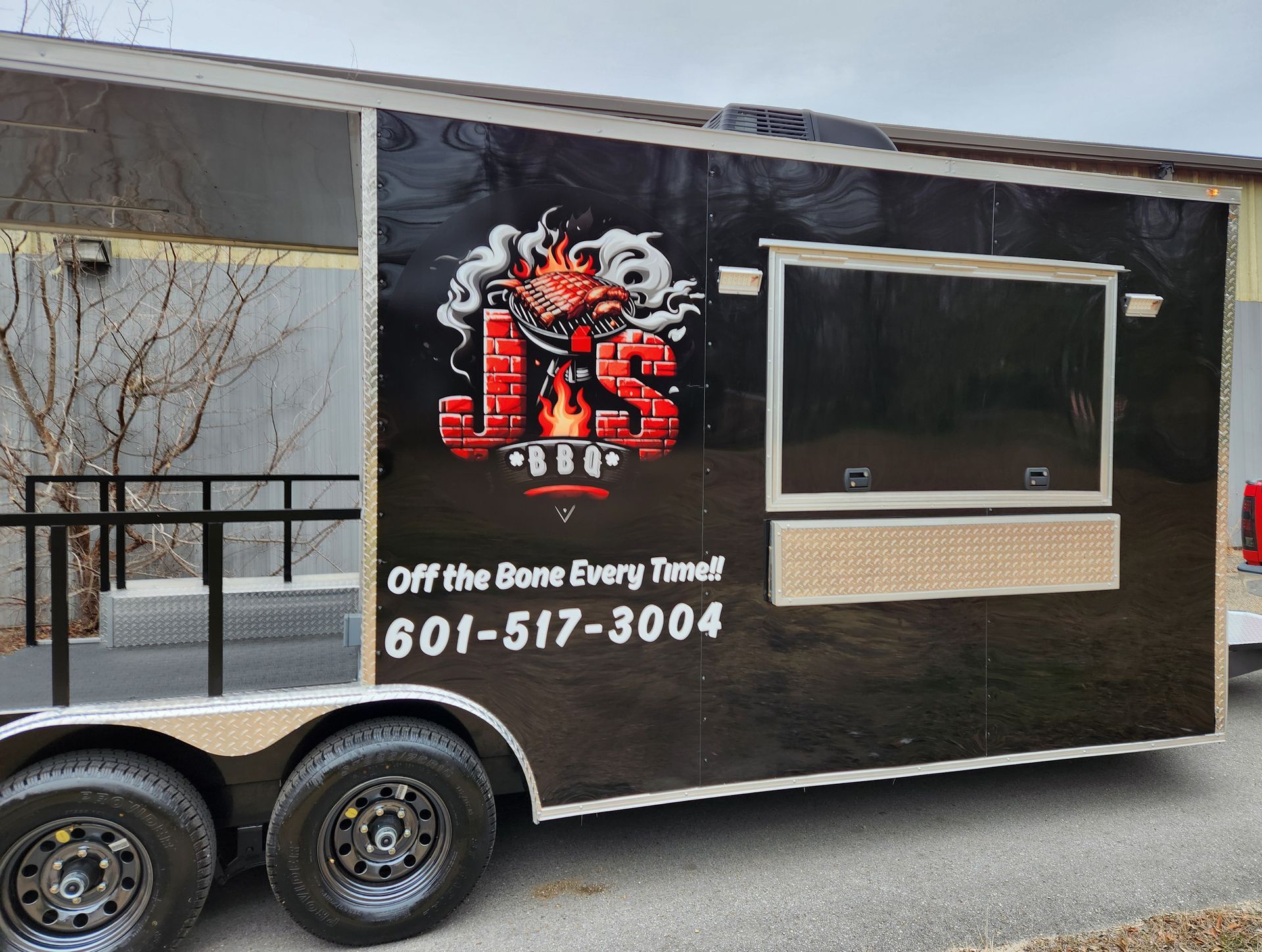 A j & s food truck is parked on the side of the road.