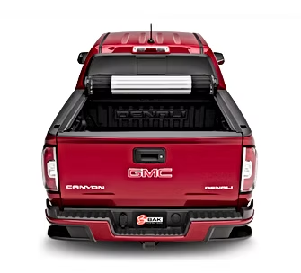 Rear view of a red GMC Canyon Denali pickup truck with a black tonneau cover. The bed is open, revealing the interior.