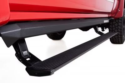 Red truck with black, retractable running board extended, providing a step for entry.