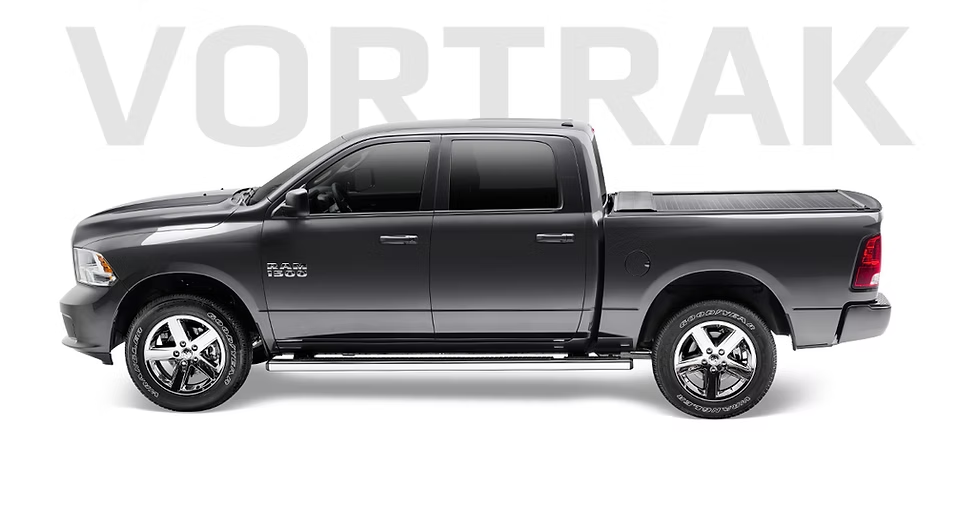 Gray pickup truck with a closed bed cover, silver wheels, and side steps.