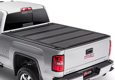 Silver GMC Sierra pickup truck with a black folding tonneau cover.