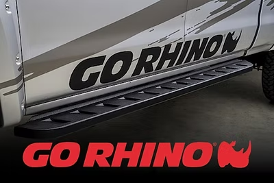 Black Go Rhino running boards on a white pickup truck. The Go Rhino logo is in red.