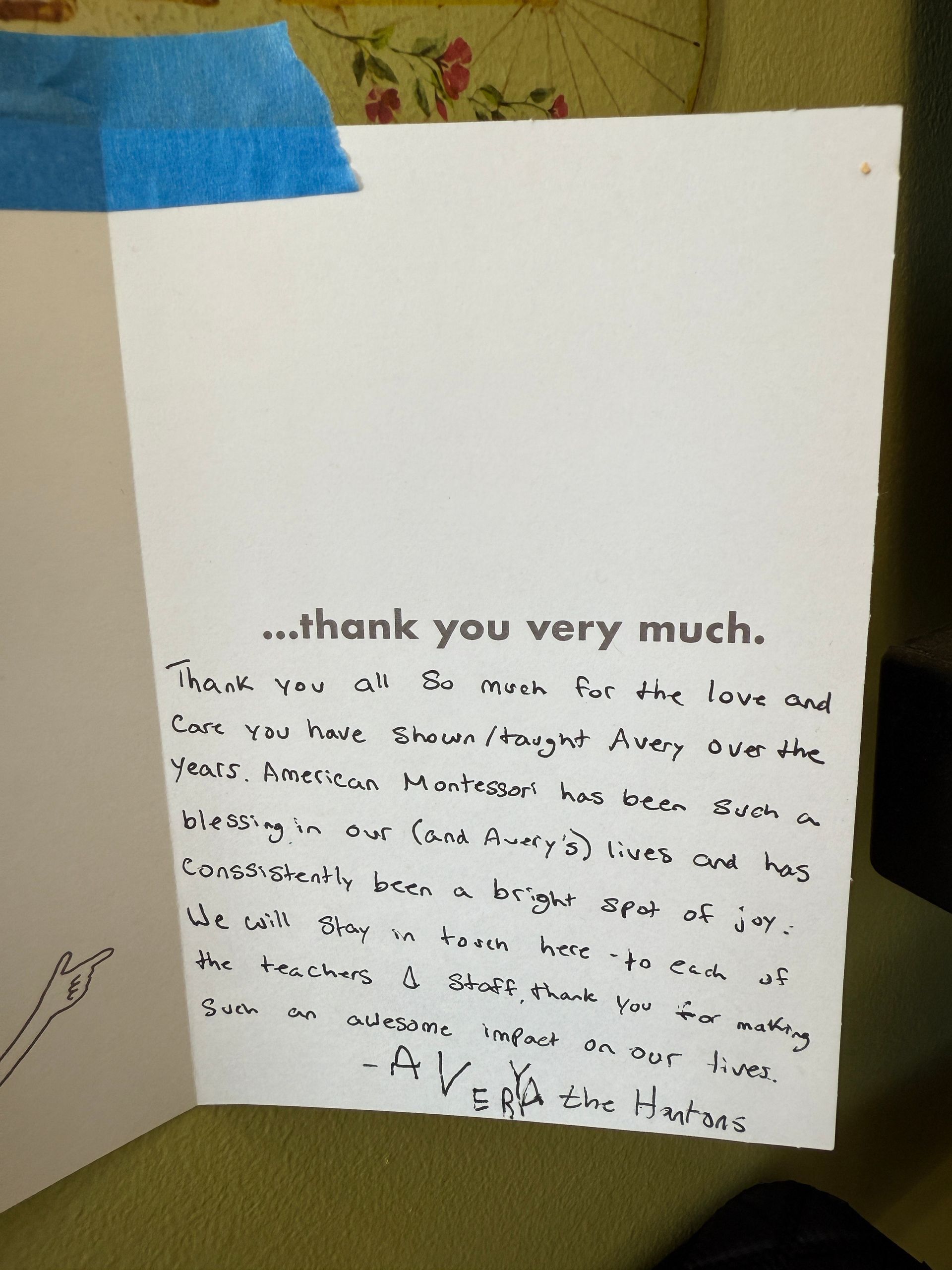 White card with handwritten message, blue tape at the top. Text says 