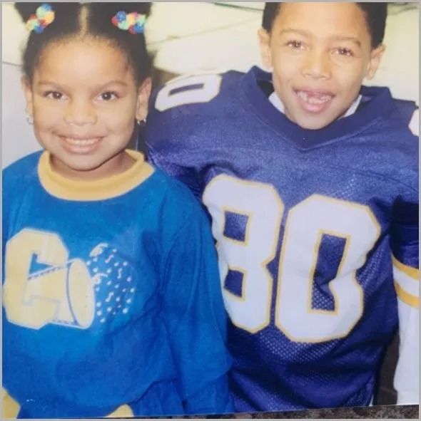 Two children smiling; girl in blue shirt, boy in football jersey.
