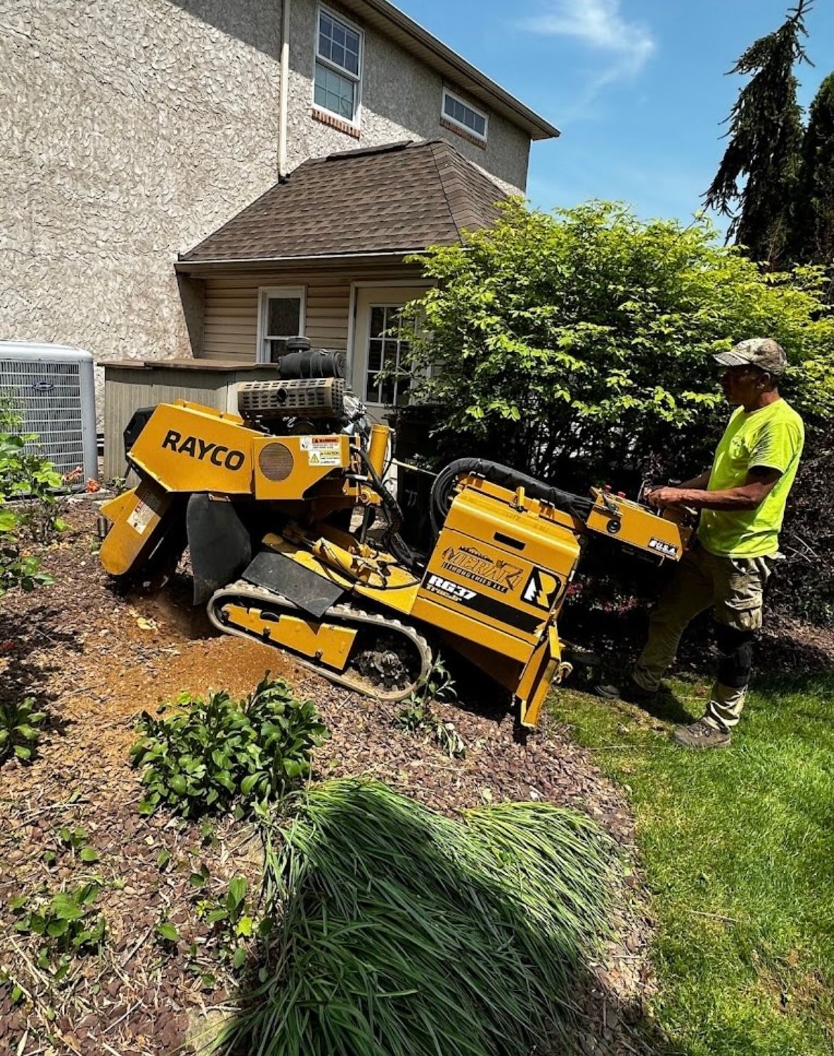 A man is using a stump grinder to remove a tree stump.