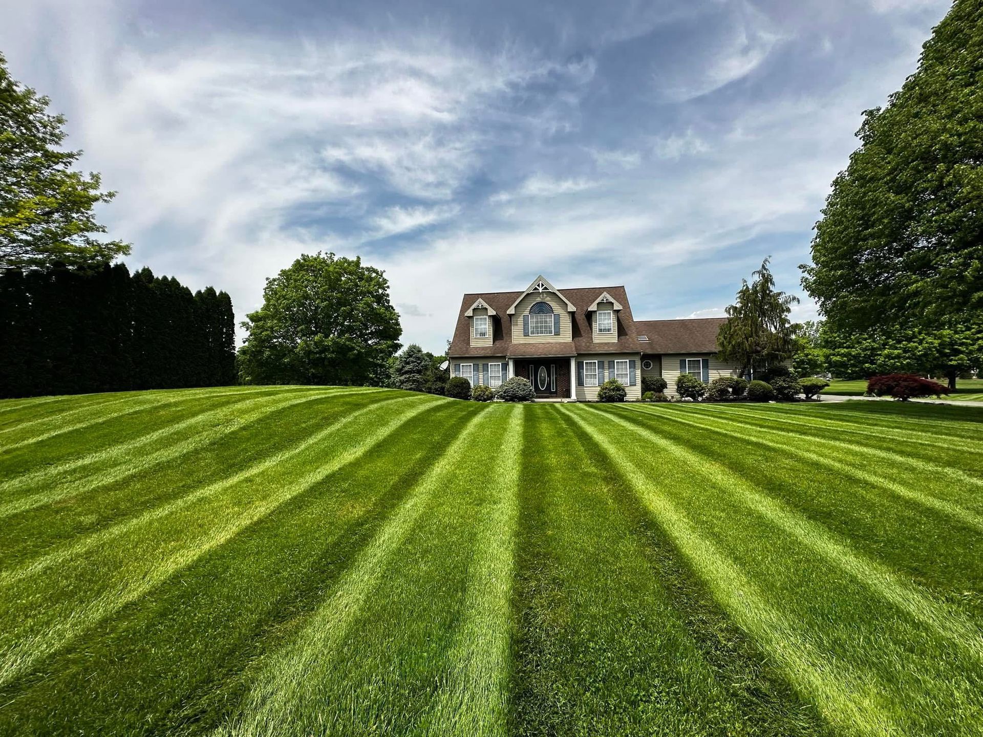 A house with a lush green lawn in front of it