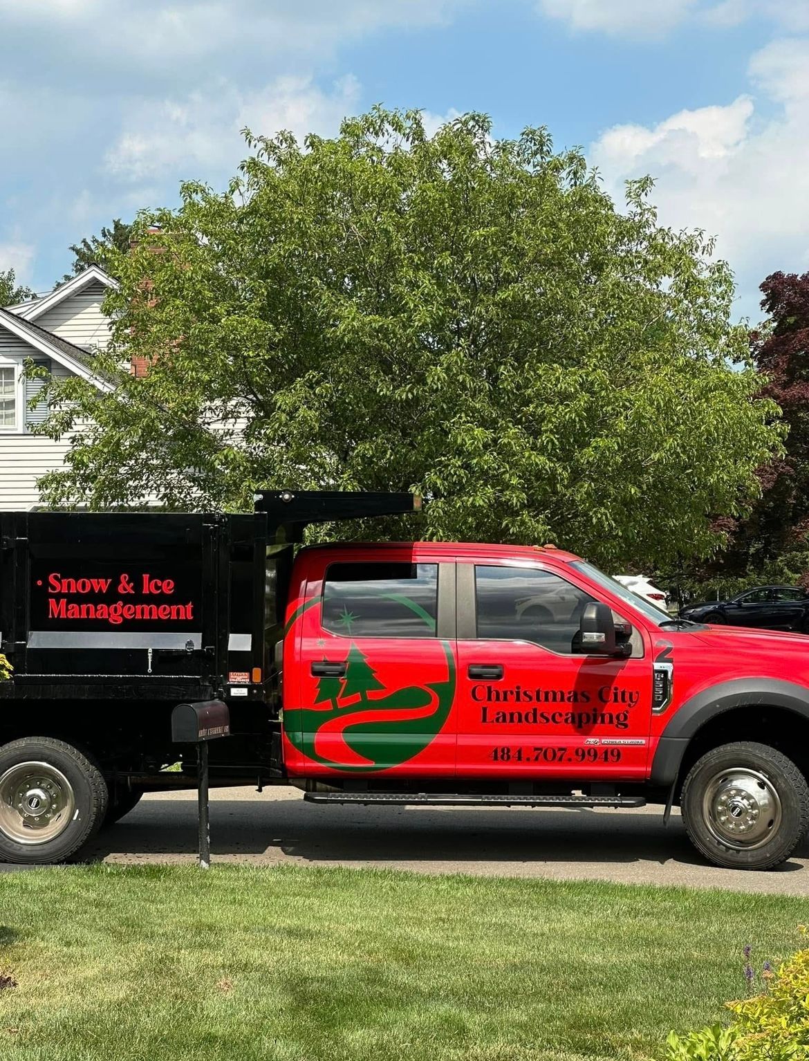 A red truck is parked in front of a house.