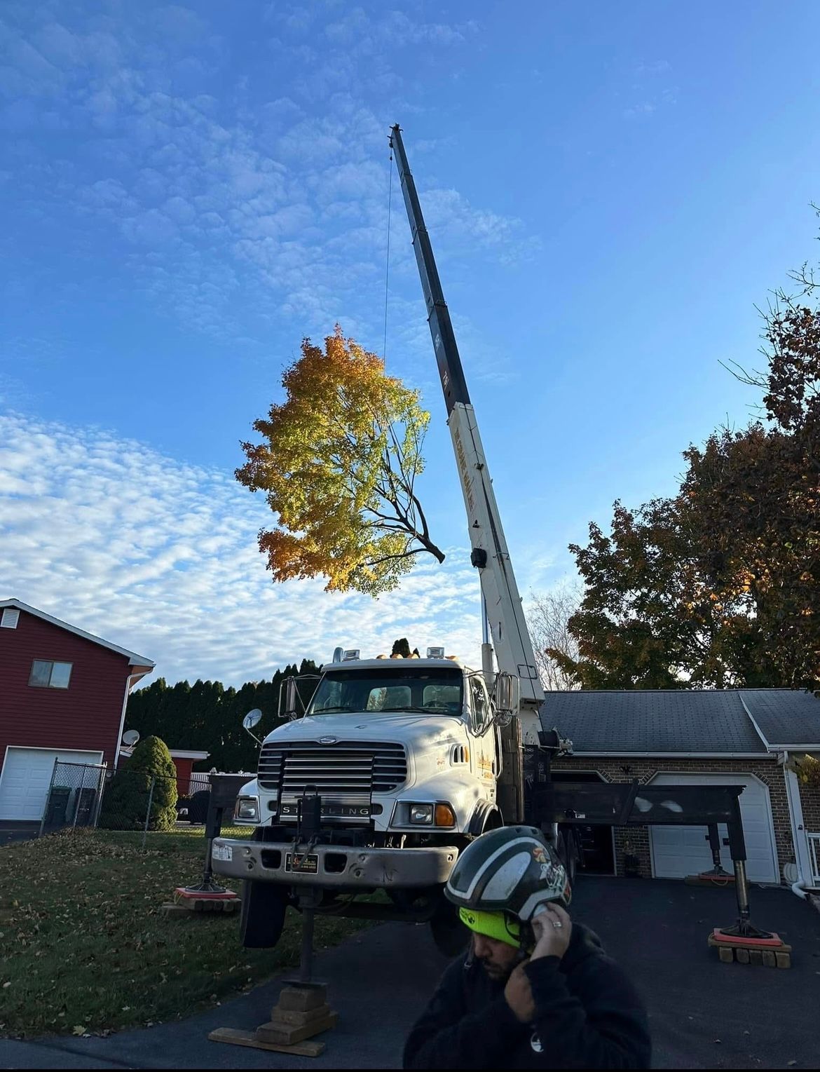 A white truck with a crane attached to it