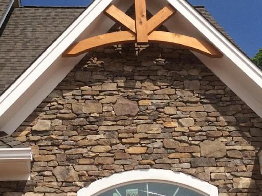 A stone wall with a window and a wooden roof