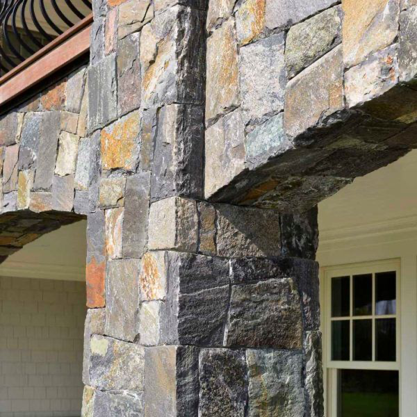 A stone wall with a window and a balcony