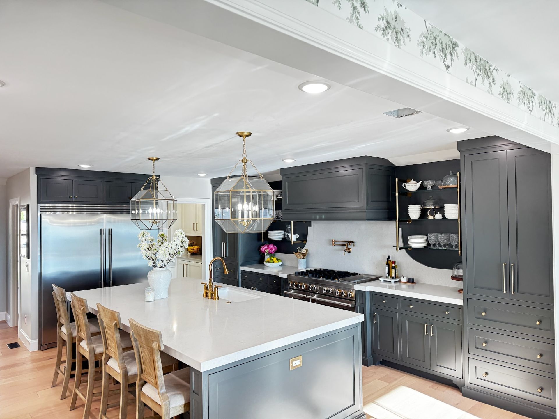 Gray kitchen with island, stainless steel appliances, and gold light fixtures