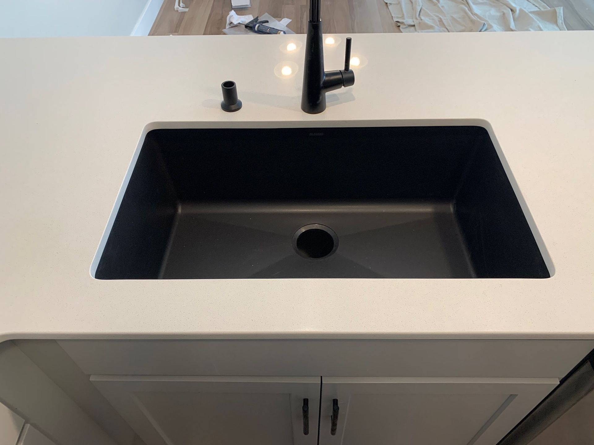 A black and white kitchen sink with a black faucet