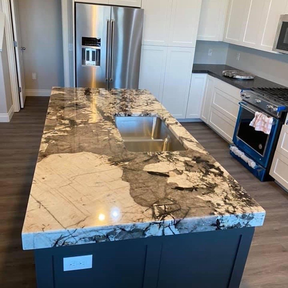 A kitchen with granite counter tops and a stainless steel refrigerator