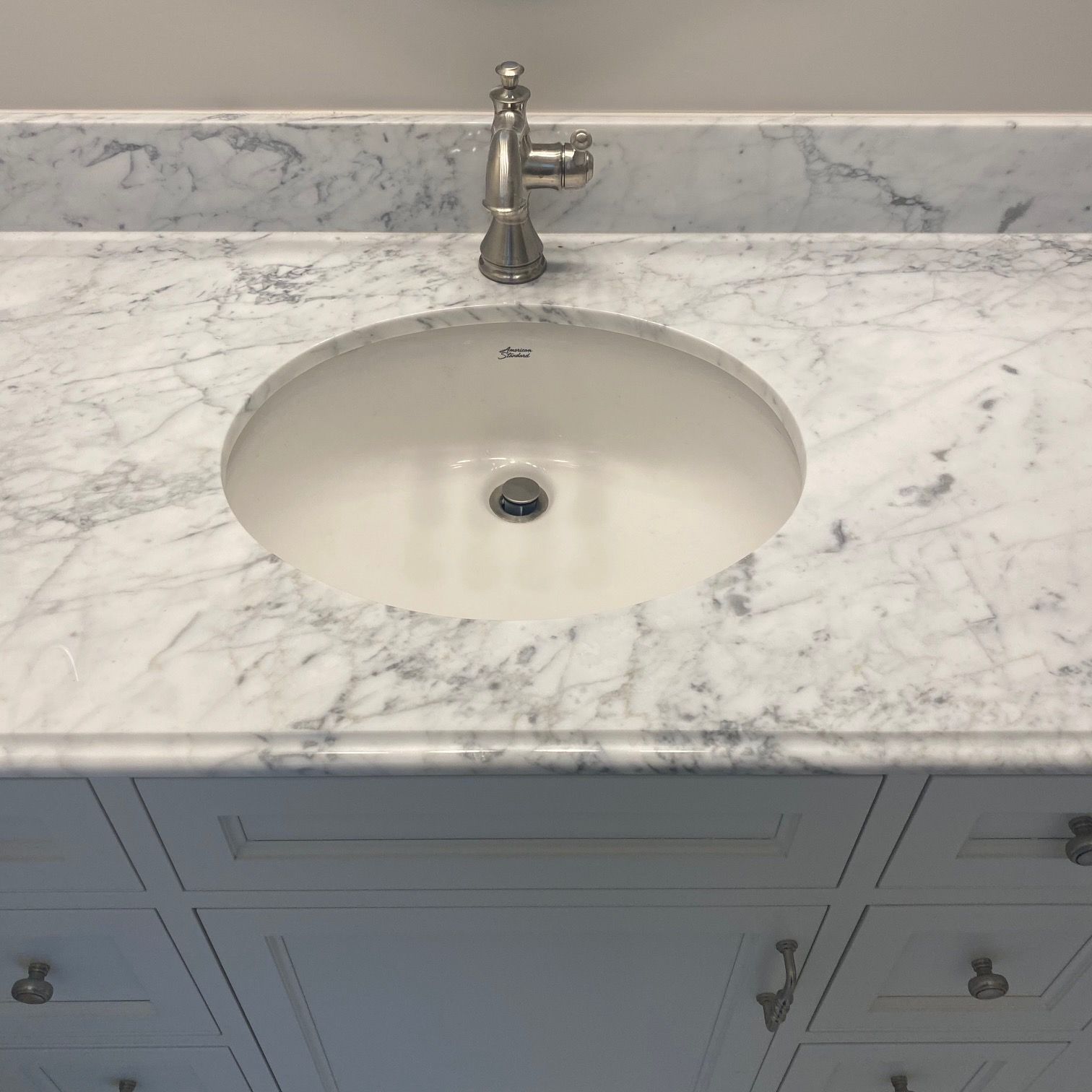 A bathroom sink with a marble counter top and a faucet.