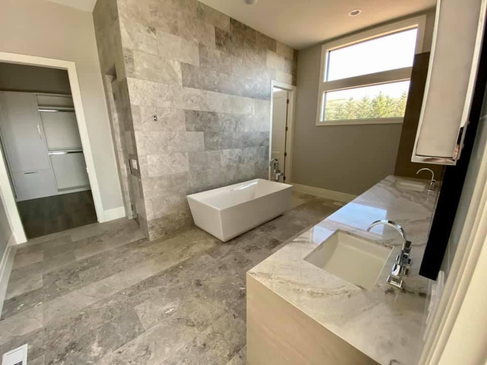 A bathroom with a tub , sink , and shower.
