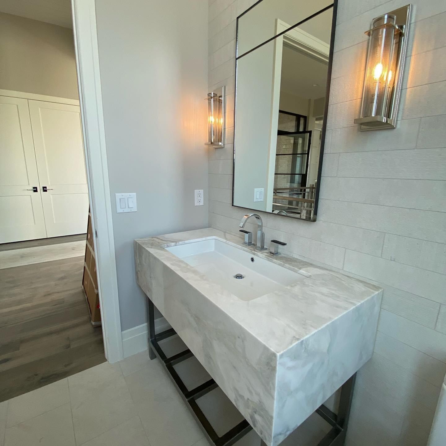 A bathroom with a large sink and a mirror