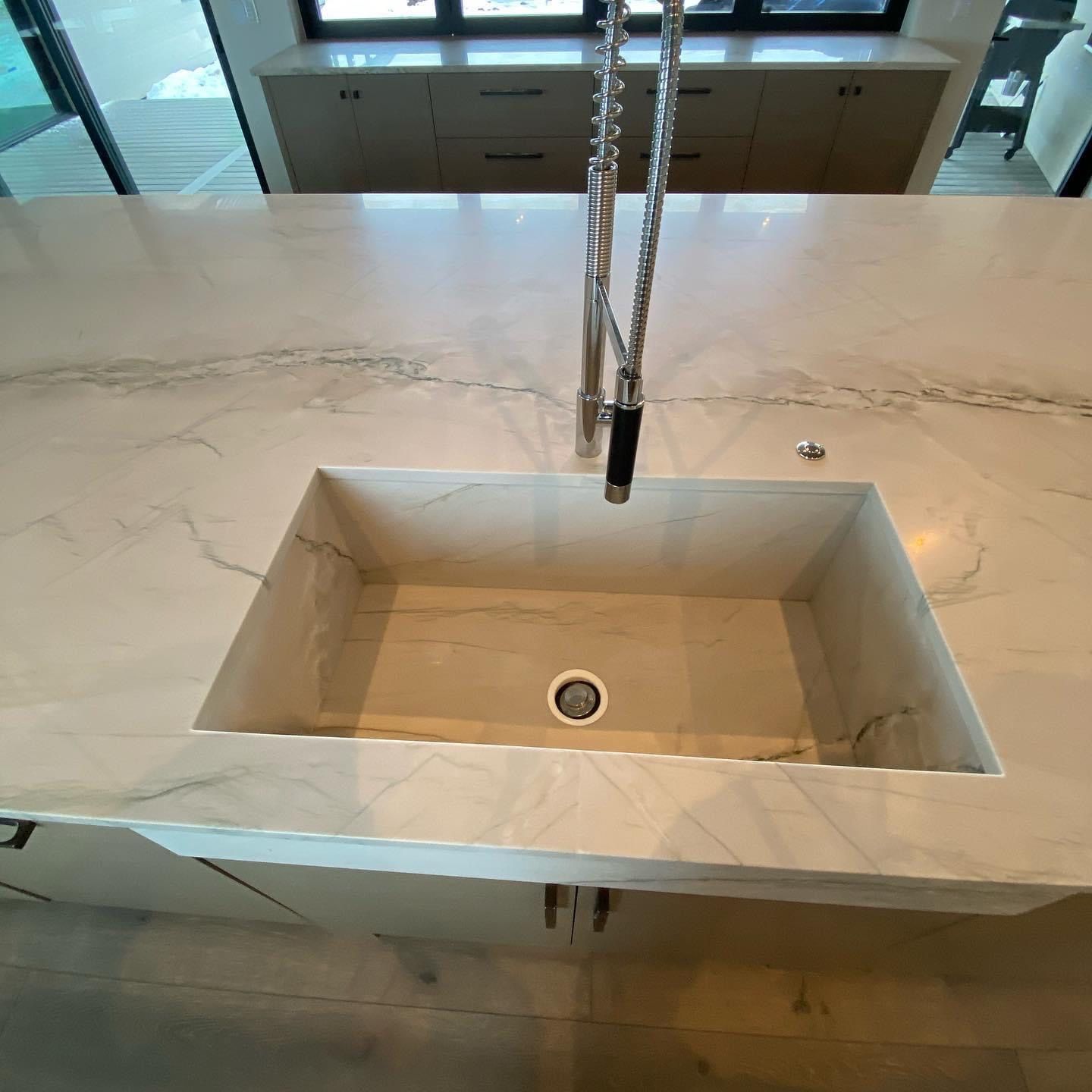 A kitchen sink with a faucet on top of it.
