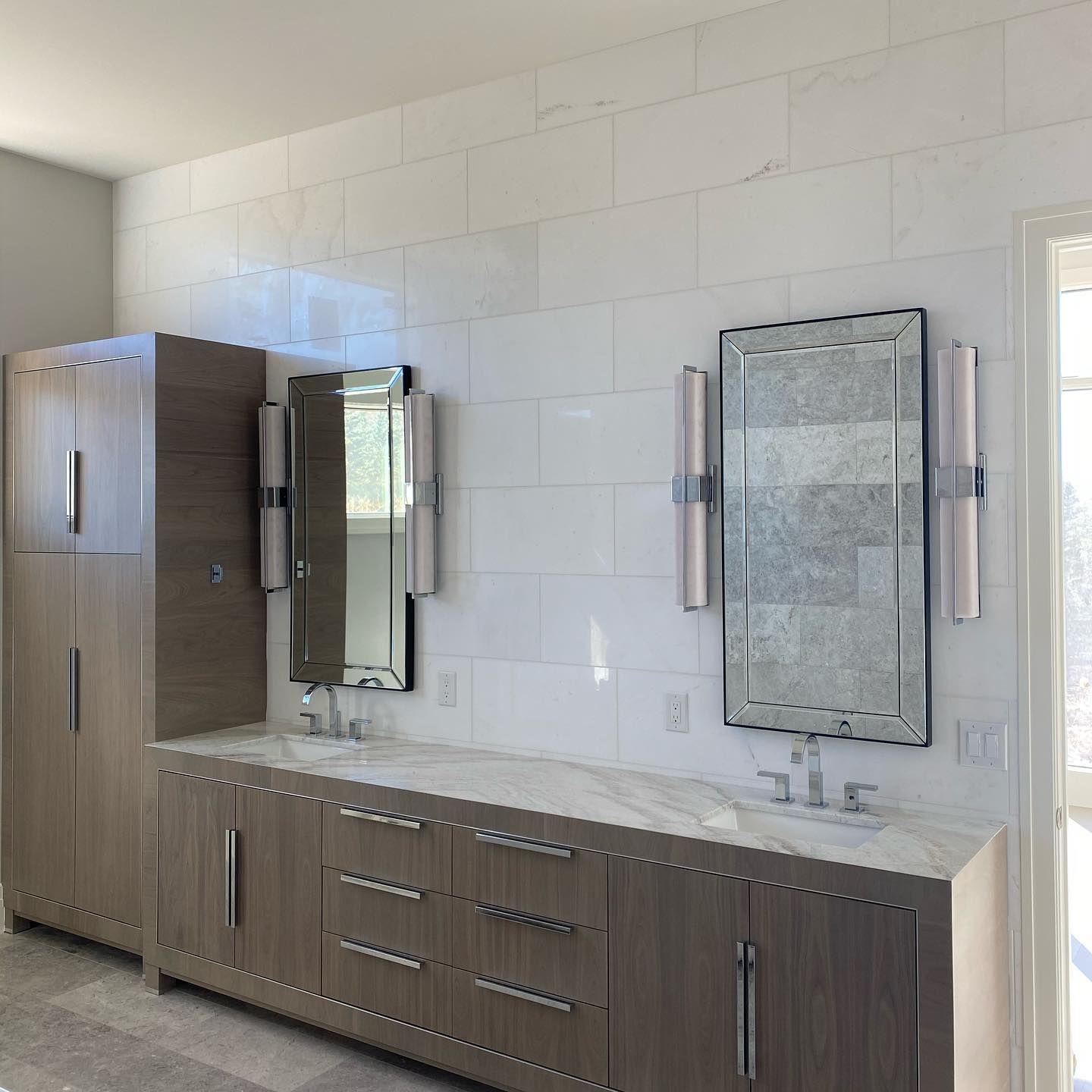 A bathroom with two sinks and two mirrors on the wall