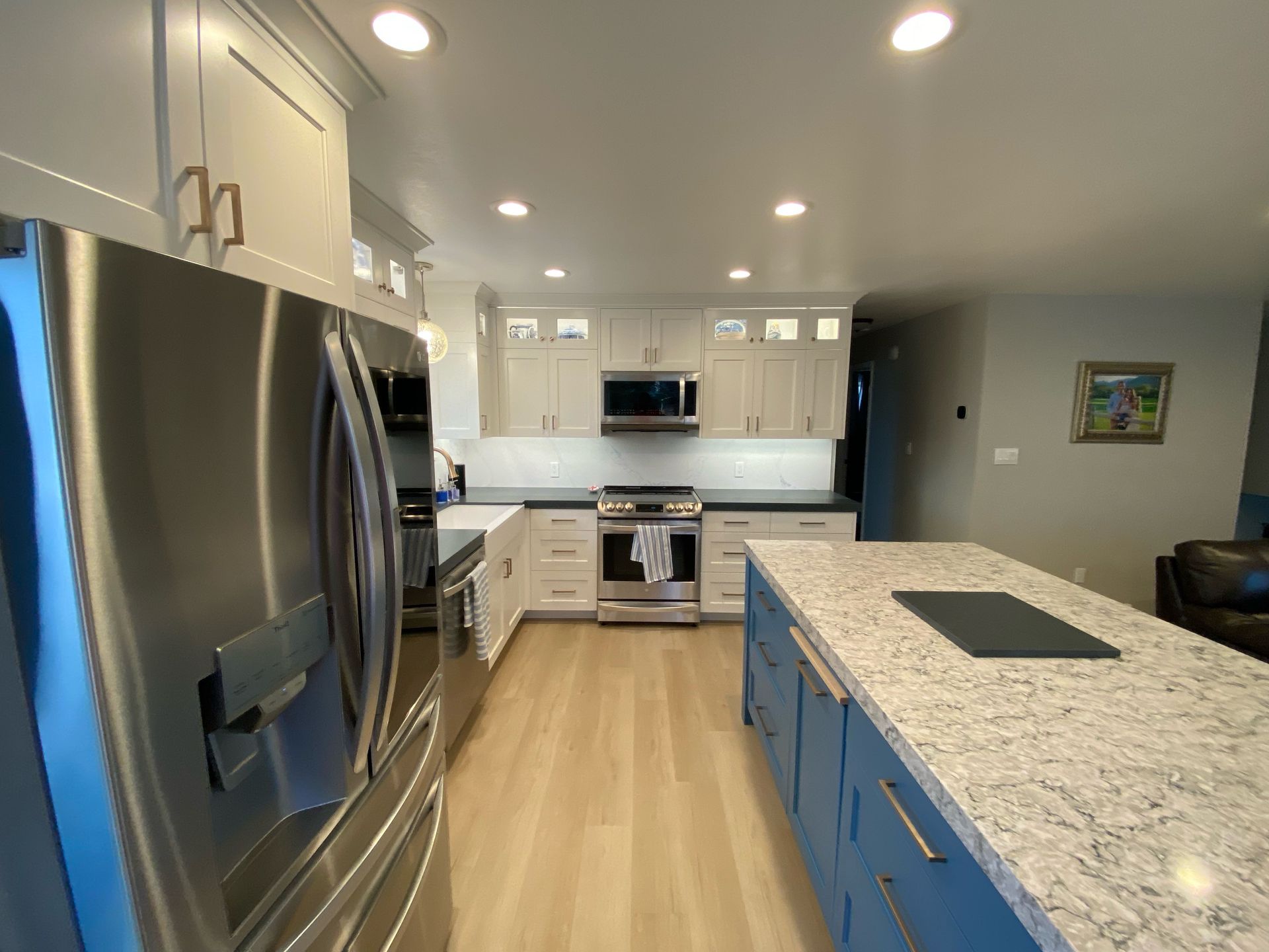 A kitchen with stainless steel appliances and blue cabinets.