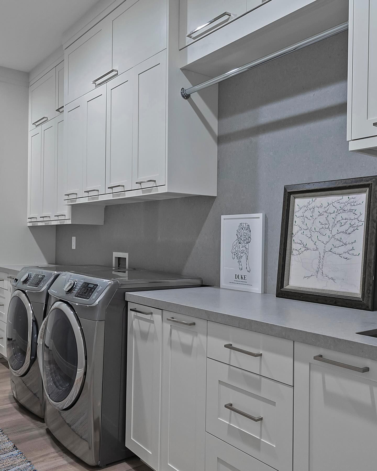 A laundry room with a washer and dryer and white cabinets.