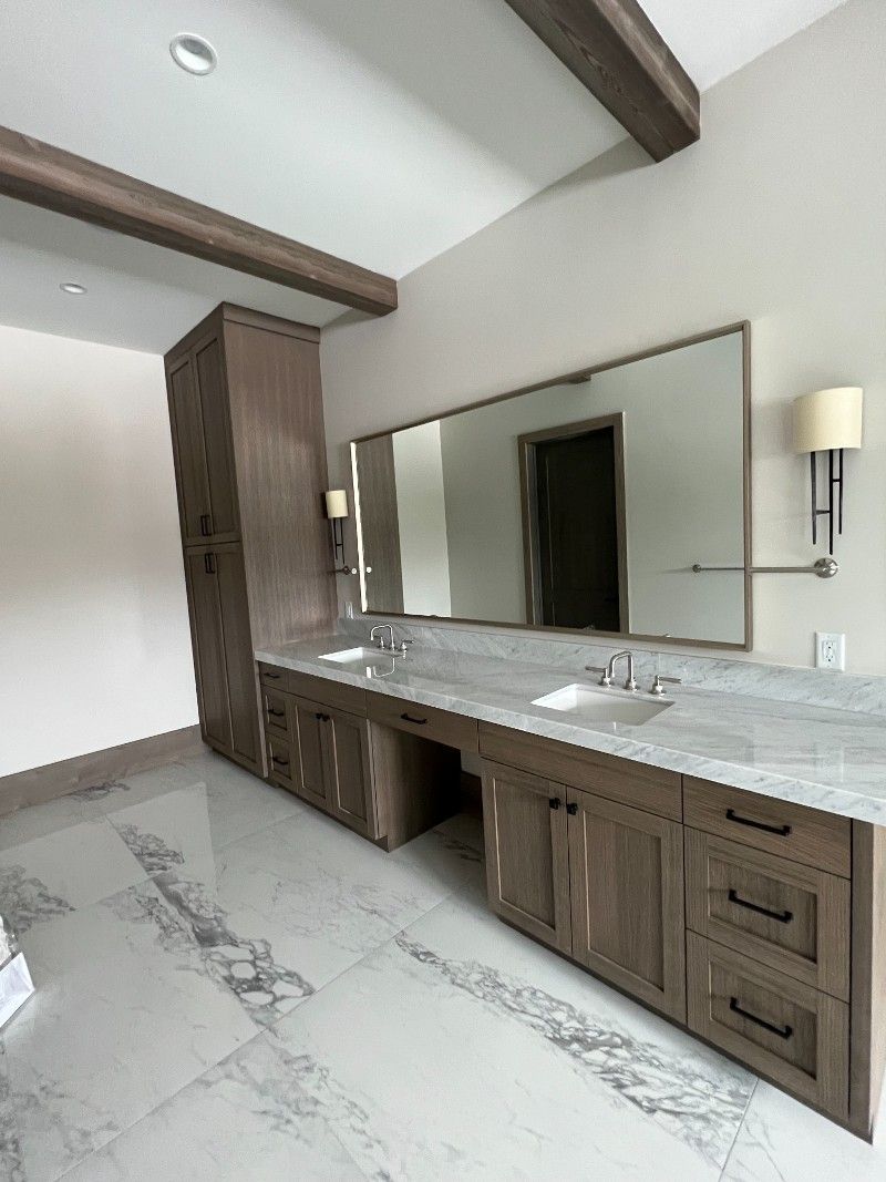 A bathroom with two sinks and a large mirror.