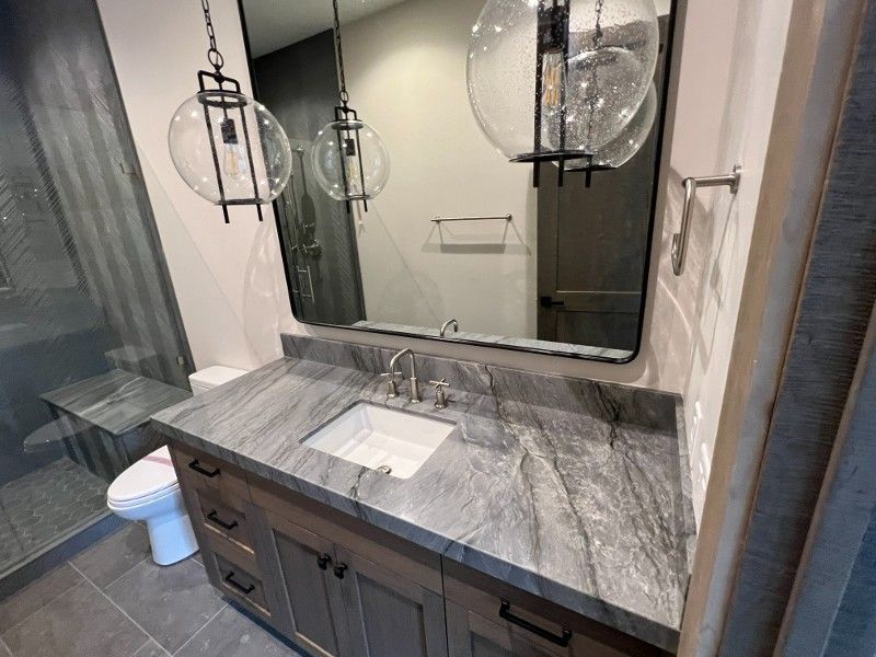 A bathroom with a sink , toilet and mirror.