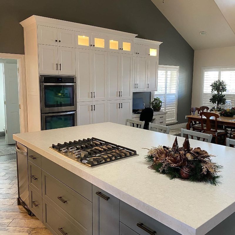 A kitchen with a large island and a stove top oven