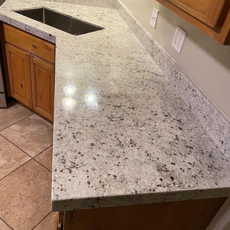 A kitchen with a granite counter top and a sink