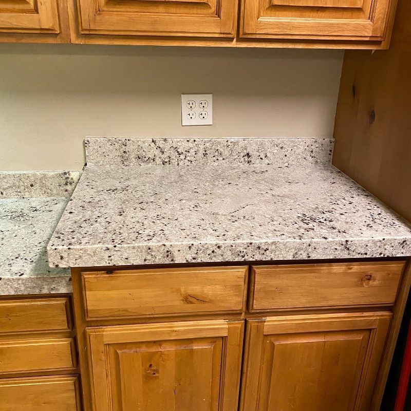 A kitchen with wooden cabinets and a granite counter top.