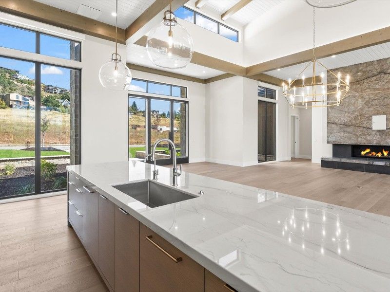 A kitchen with a sink and a large island in the middle of the room.