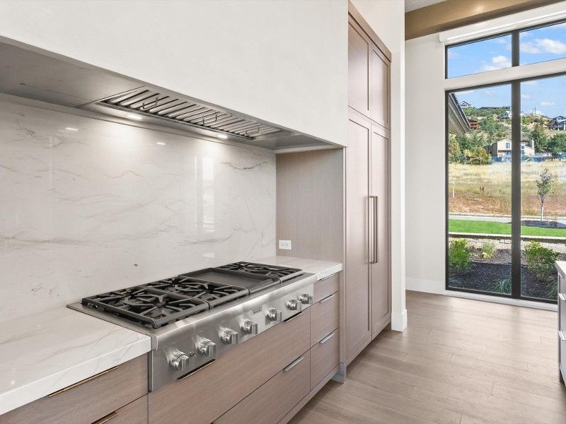 A kitchen with a stove top oven and a refrigerator.
