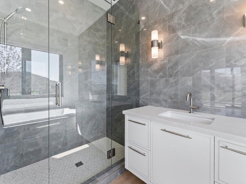 A bathroom with a walk in shower and a sink.
