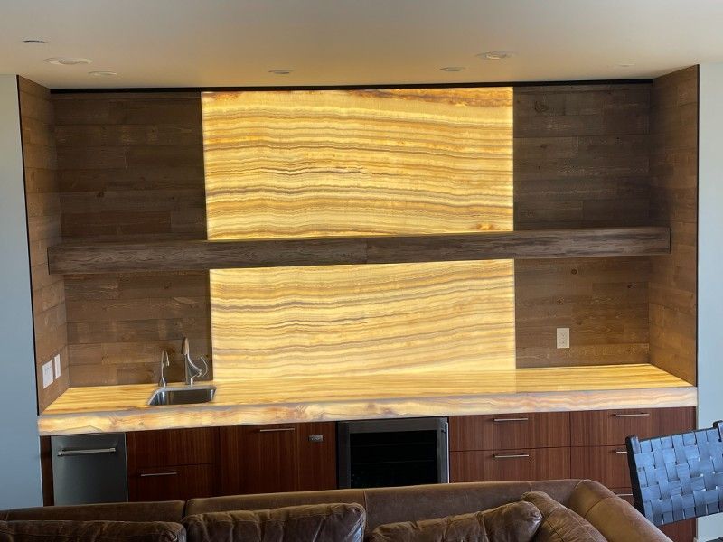 A living room with a couch , sink , and wooden cabinets.