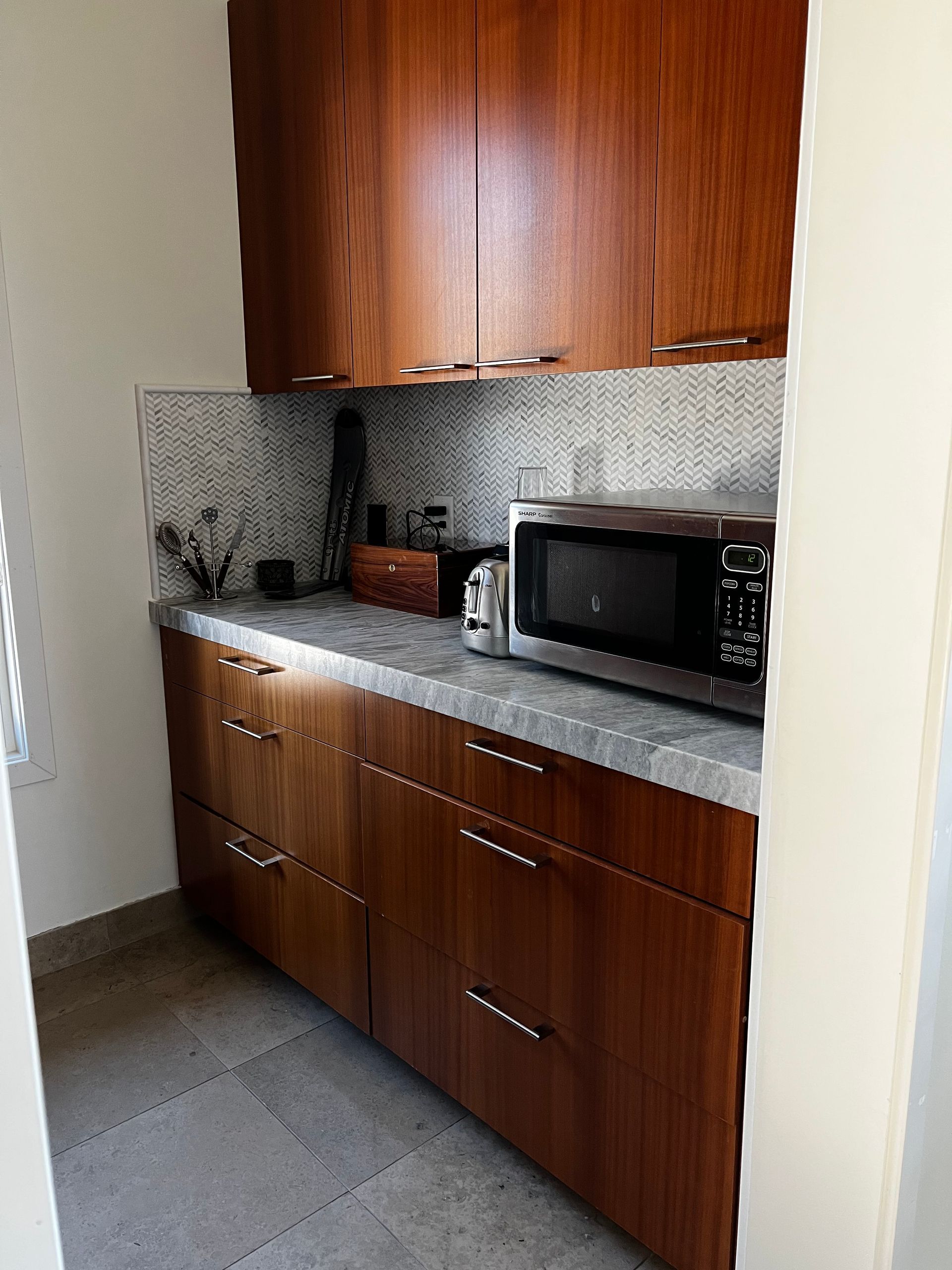 A kitchen with wooden cabinets and a microwave