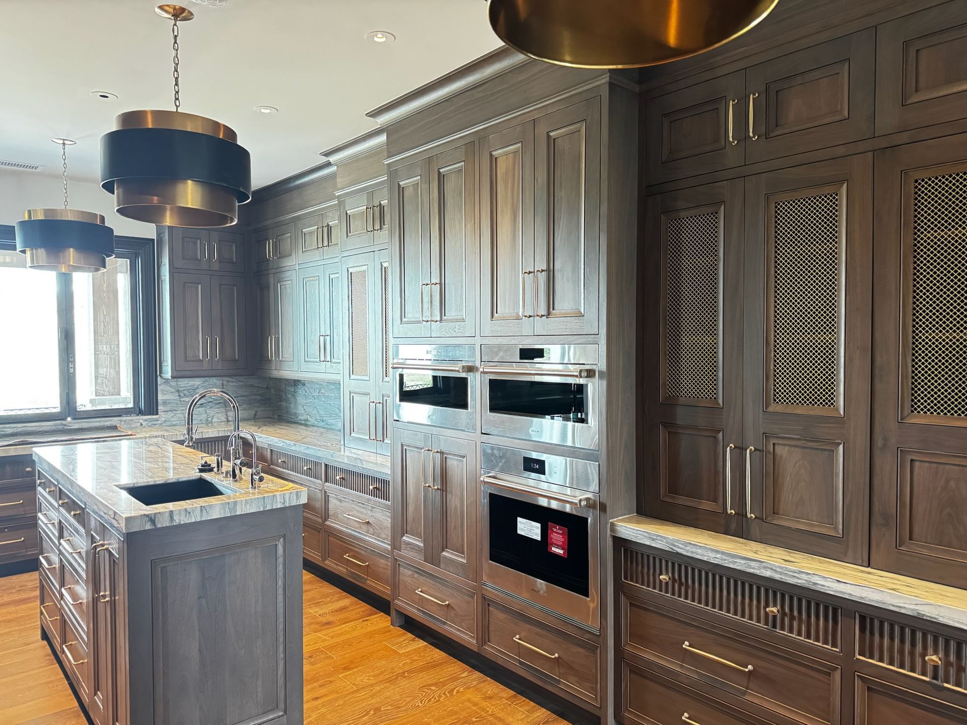 Luxurious kitchen with wood cabinets, island, granite countertops, and modern appliances