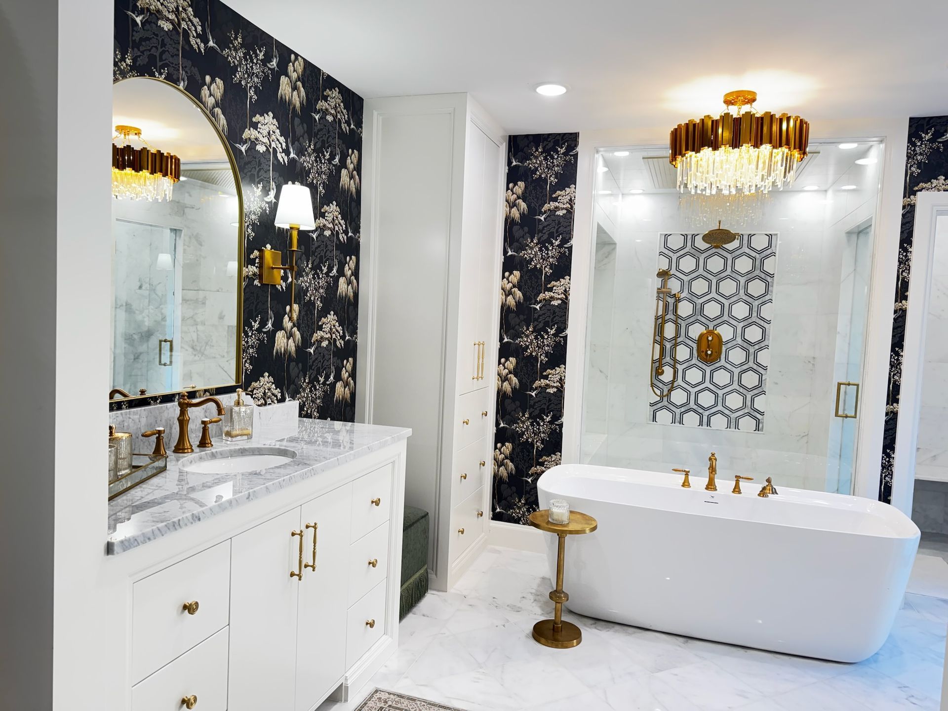 Elegant bathroom with floral wallpaper, a white bathtub, and gold accents
