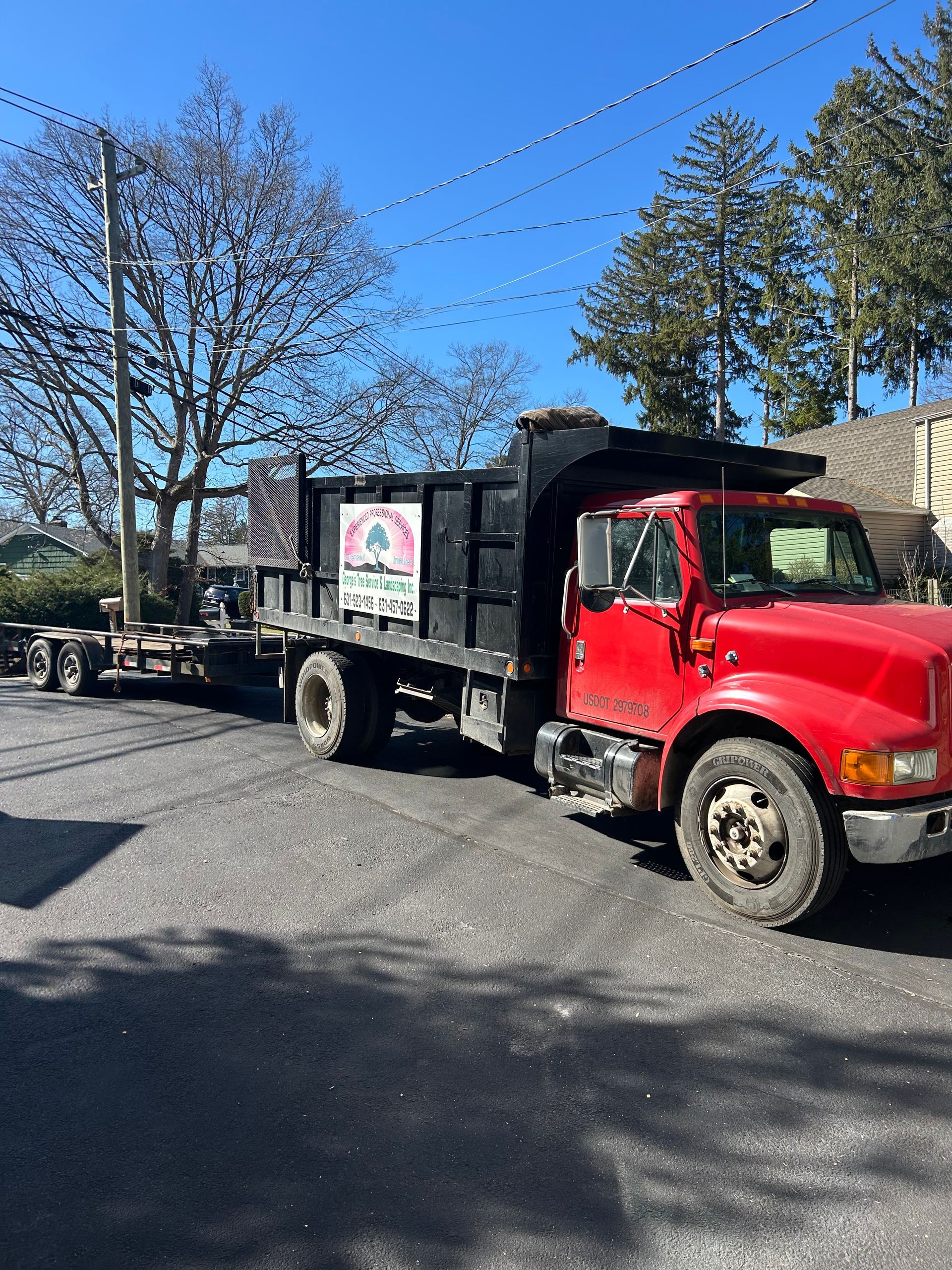 A red dump truck is parked in a parking lot.