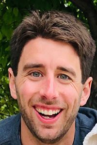 Smiling man with light eyes and brown hair.