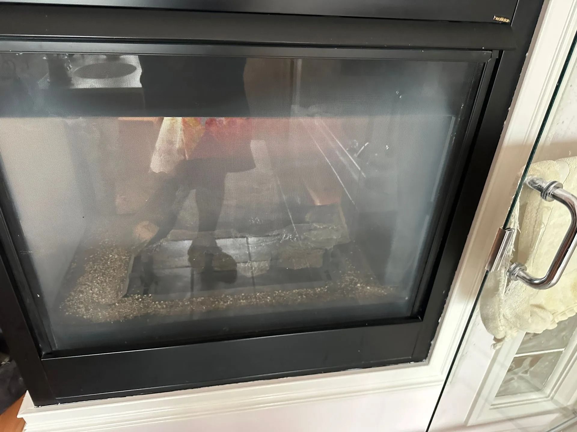 Glass-front fireplace with a black frame and a decorative interior, likely gas-powered.