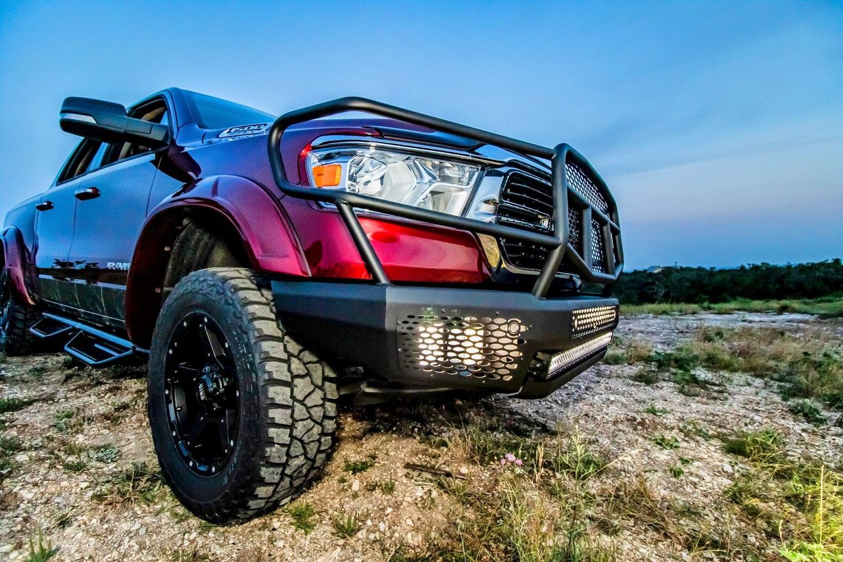 Silver lifted pickup truck with off-road tires and black front bumper on a white background
