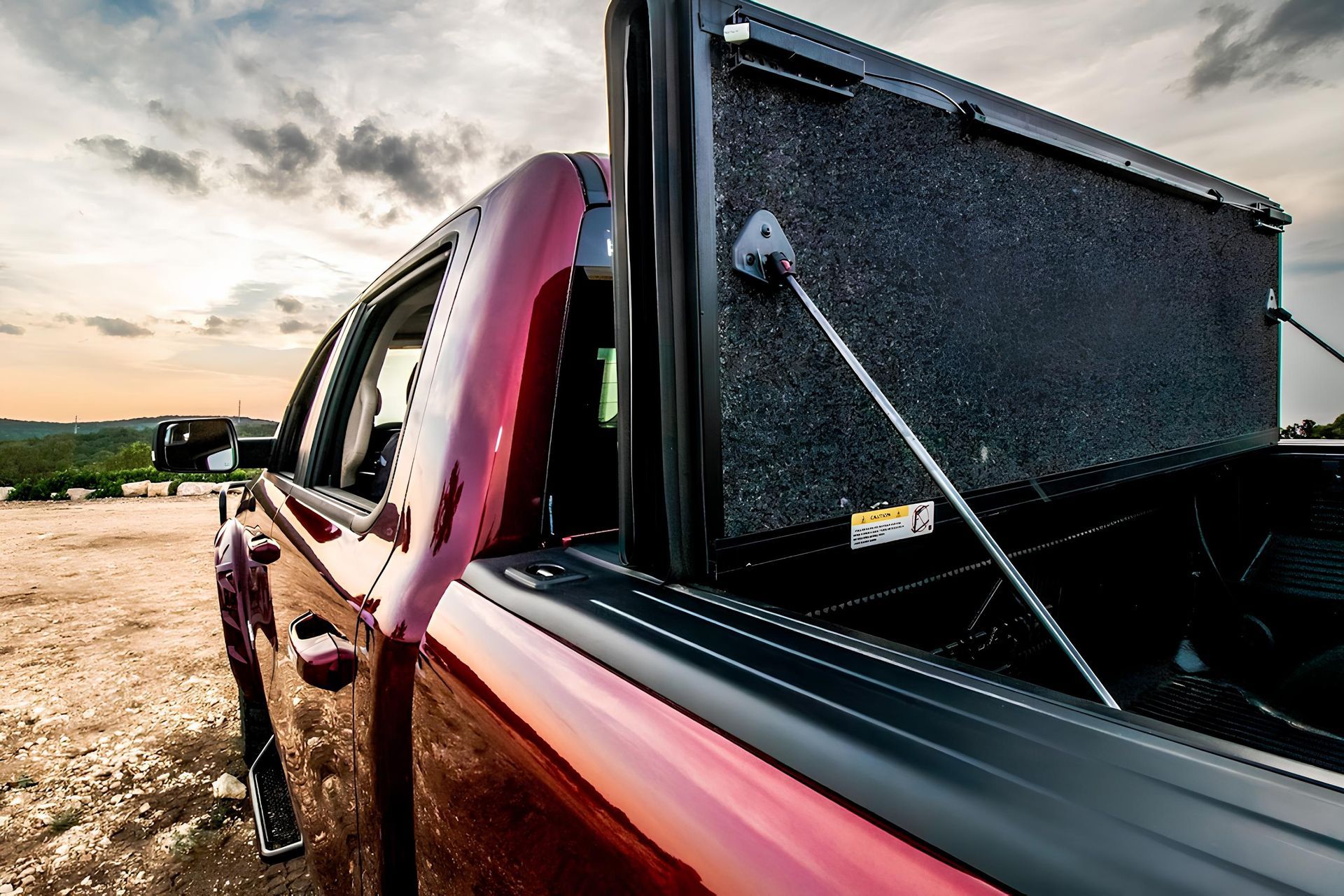 Close-up of a black hard-shell car roof cargo box with textured lid outdoors