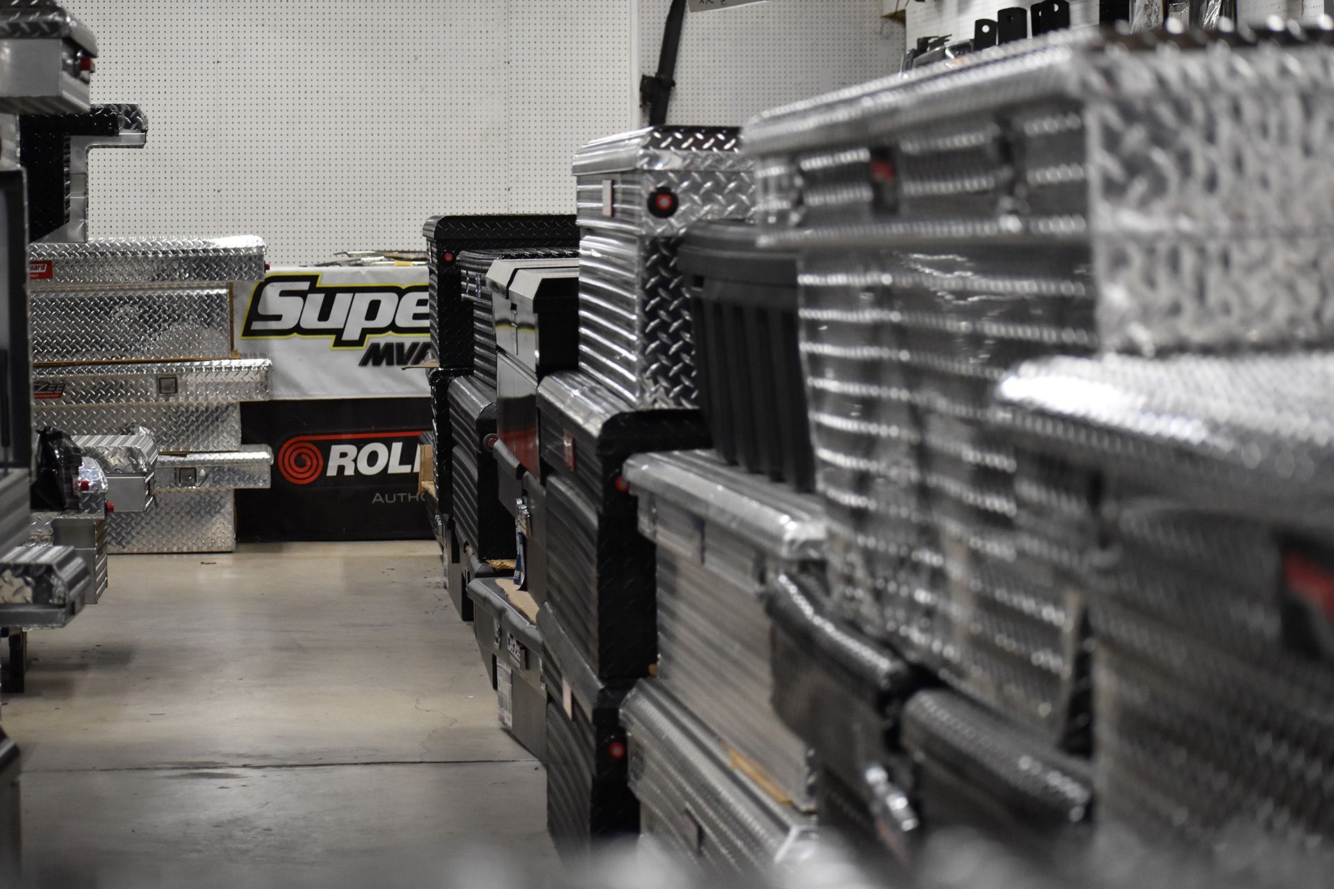 Rows of chrome tool chests in a workshop aisle, with a blurred garage wall in the background