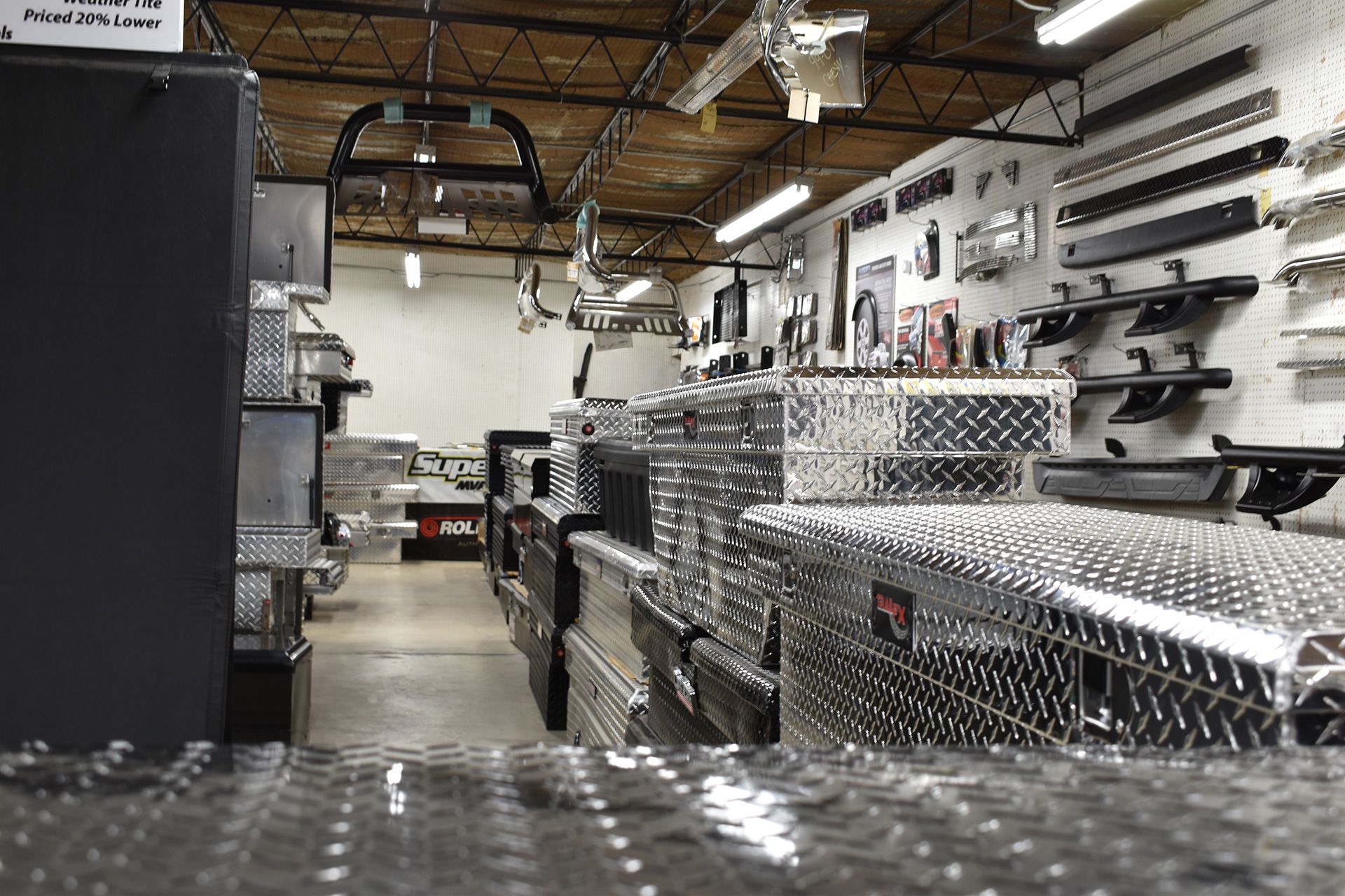 Industrial workshop with diamond-plate metal cabinets, tools on the walls, and exposed ceiling pipes