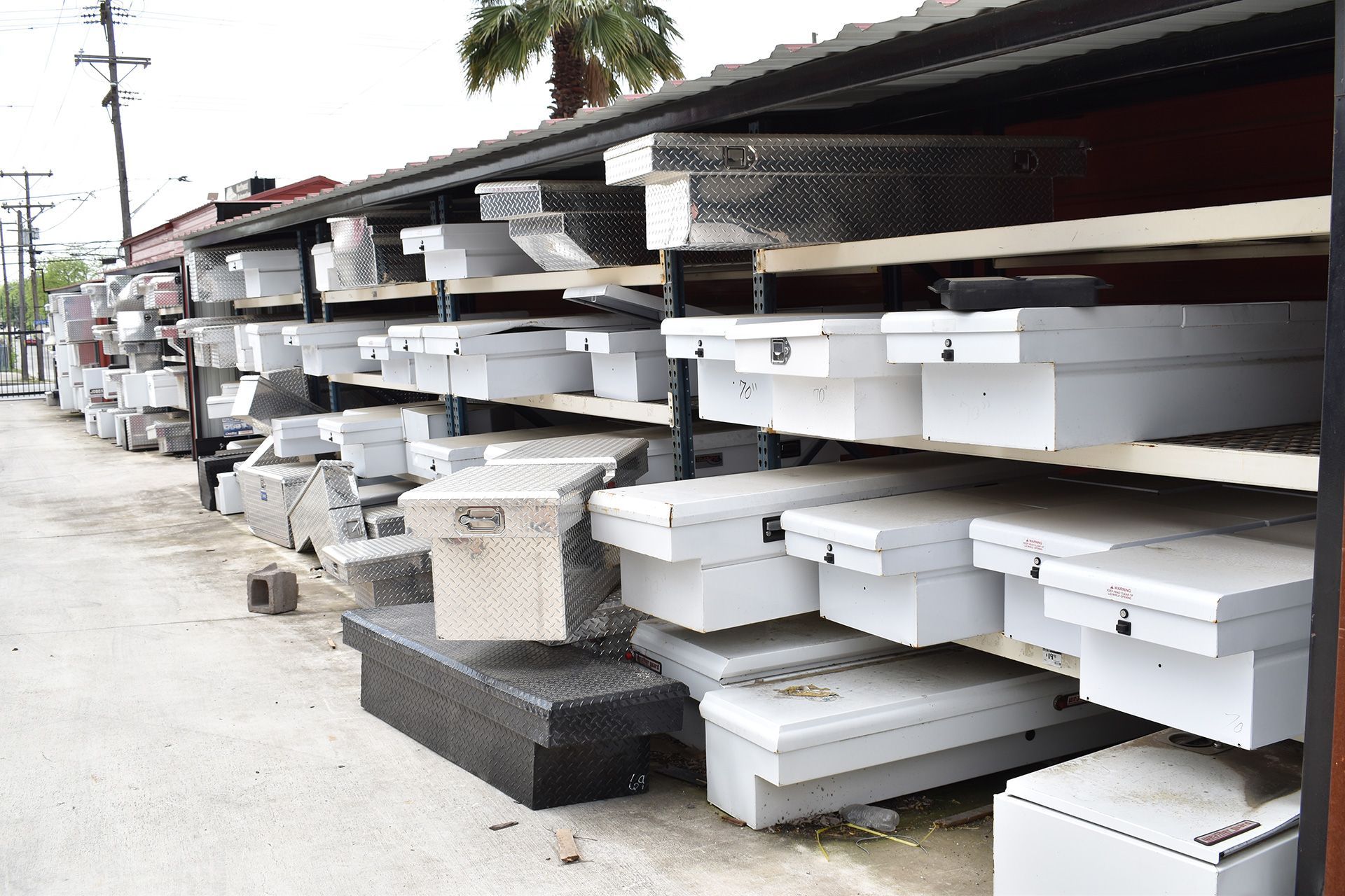 Stacks of white and black foam blocks stored along a sidewalk beside a building