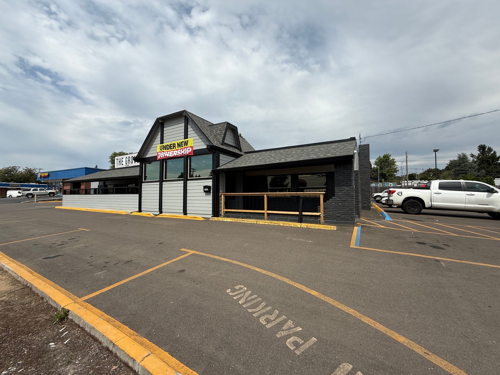 Restaurant exterior with a parking area and overcast sky.