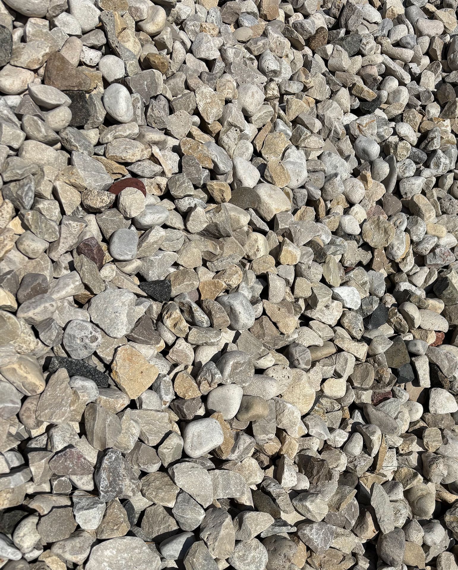 Close-up of gray and tan gravel stones filling the frame