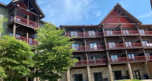 A large building with a lot of balconies and trees in front of it.