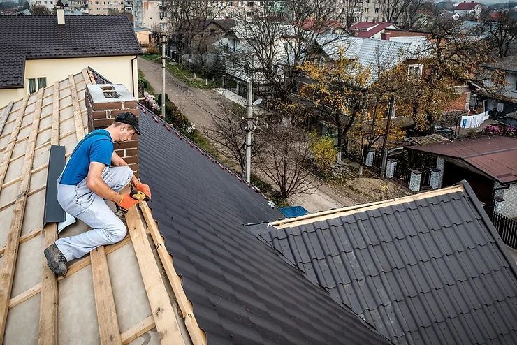 A man is working on the roof of a house.