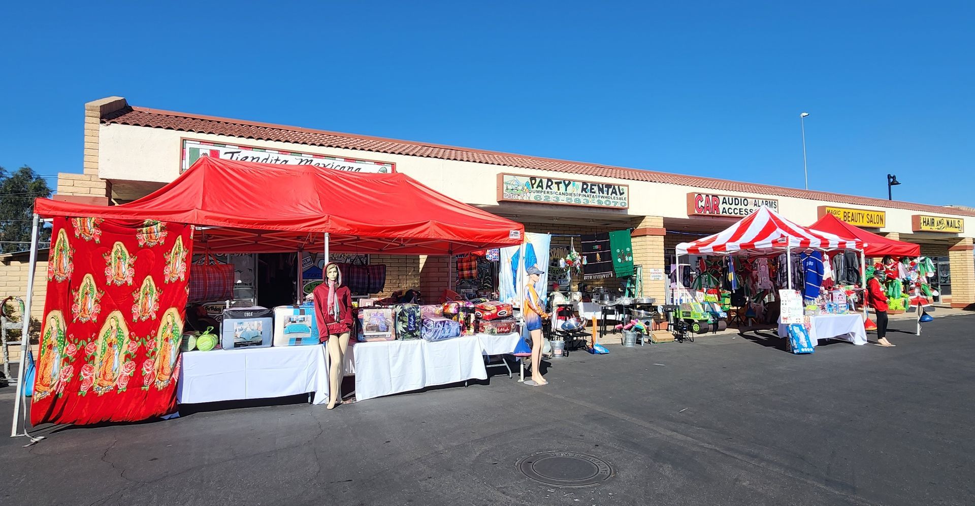 a row of red and white tents are lined up in front of a building .