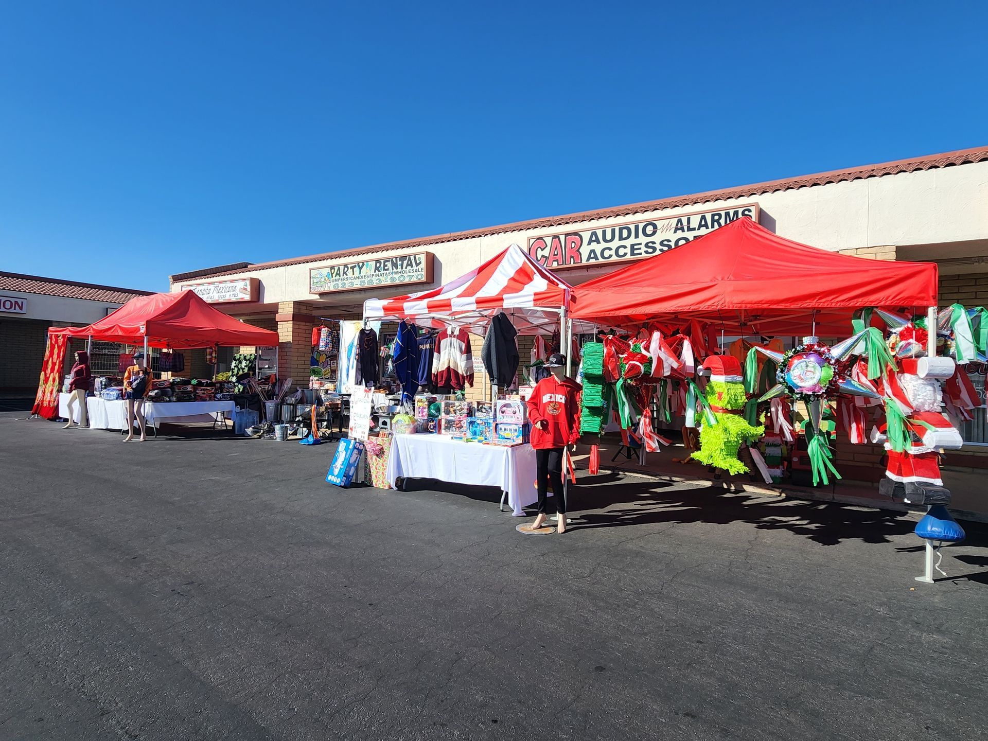a row of tents are lined up in front of a building .